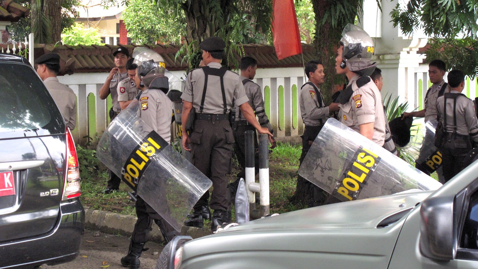 Indonesian National Police officers with riot shields marked POLISI stand outside a building in Bengkulu, Indonesia.